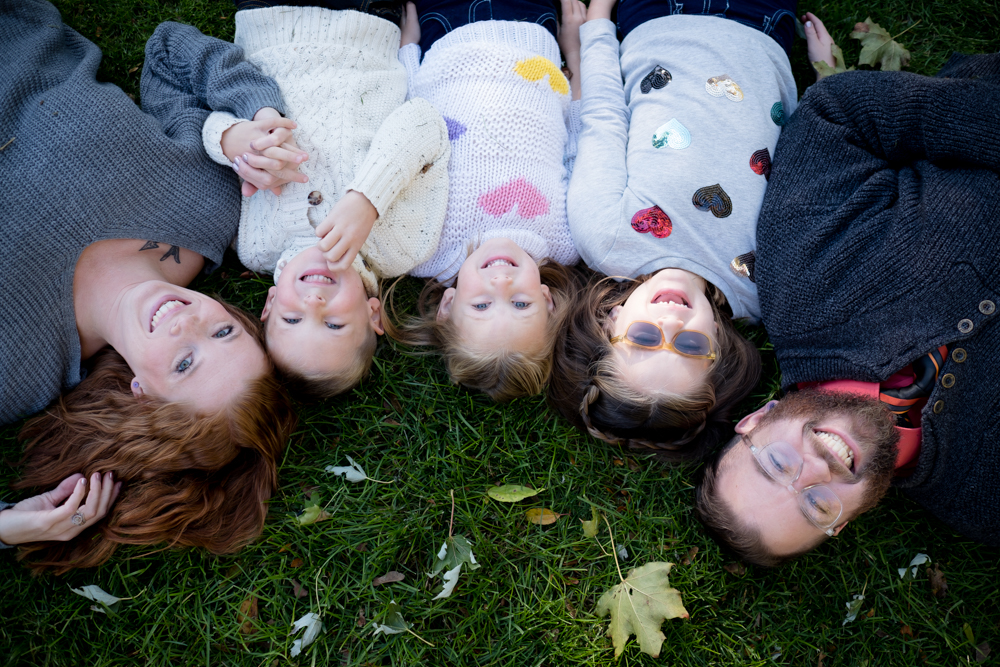 Family smiles upside down in the grass